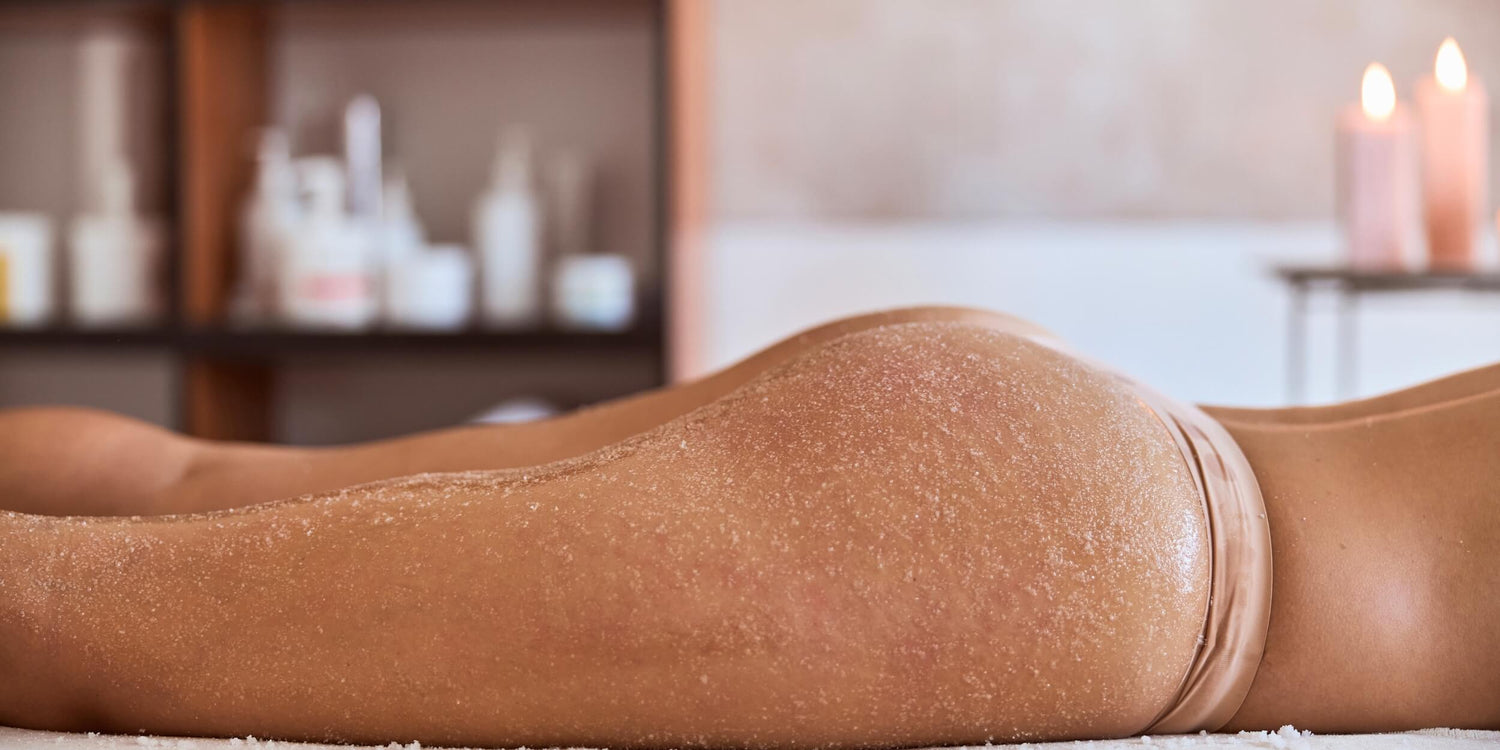 Esthetician performing a Booty Facial to exfoliate and smooth the skin on the glutes.
